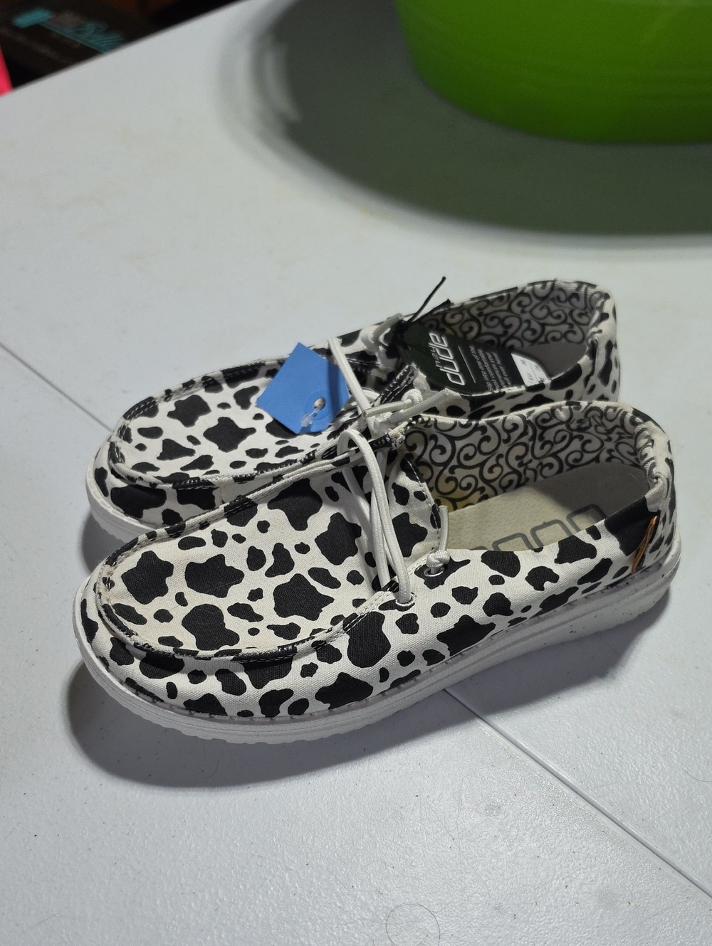 Hey Dude Kids Cow Print Slip-On Shoes in Black and White